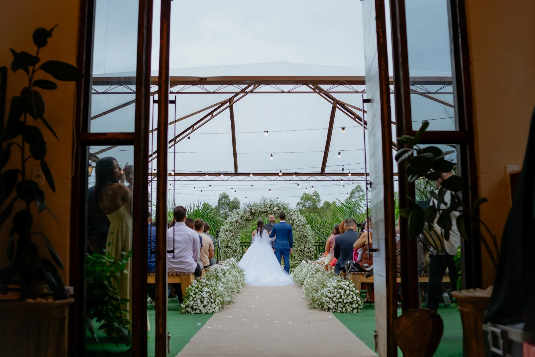 Casal seguindo pelo jardim após a cerimônia de casamento